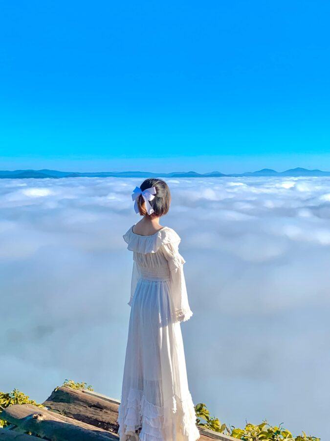 Váy trắng dài kết hợp với biển mây tạo nên một bức ảnh siêu đẹp